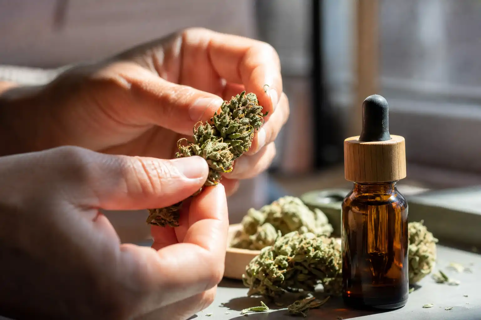 Des mains examinent un objet, autour de cbd contre stress, près d'une fenêtre.